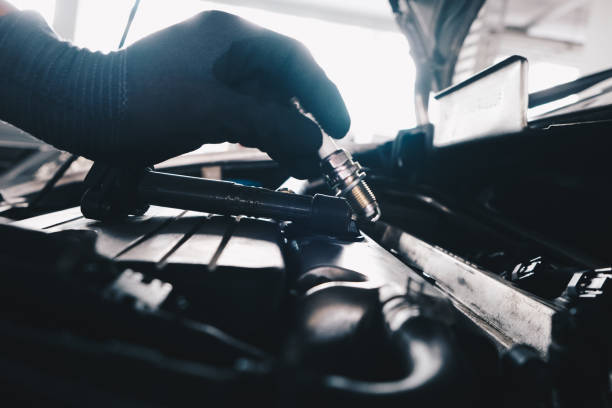 Mechanical man hand checking and change ignition coil with spark plug of car engine