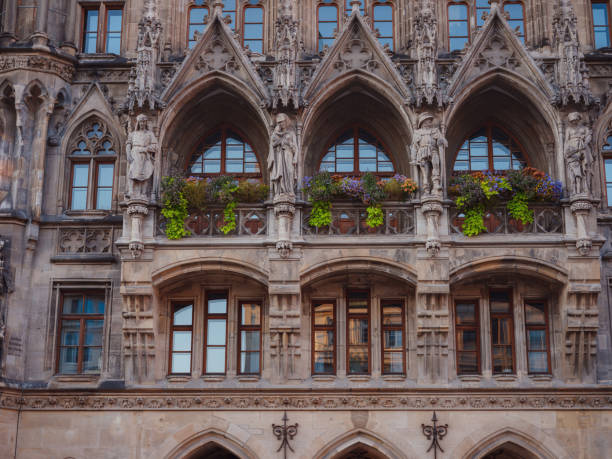 Facade of Neo-Gothic town hall with daily performances to the sound of bells and a tall tower overlooking the city in Marienplatz Munich