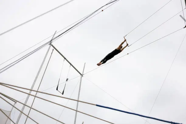 Mature trapeze artist flying in the sky