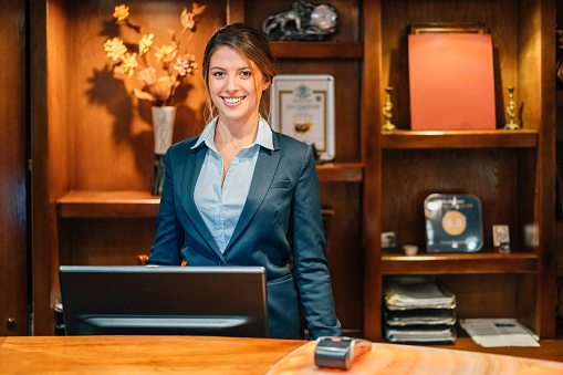 Young Caucasian receptionist in hotel having a conversation over the phone