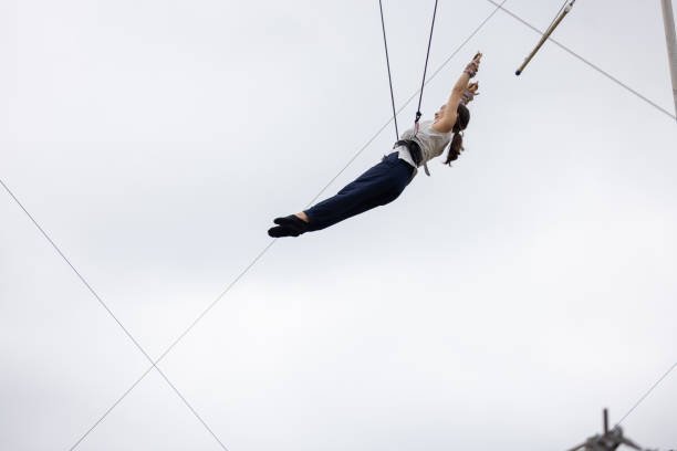 istock Young woman practicing trapeze and flying in the sky 1456581613