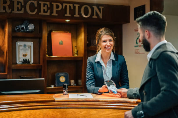 Businessman paying contactless with credit card at the hotel reception