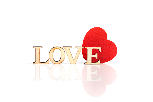 Love word made with wooden letters and heart on a white background