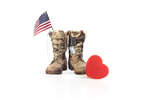 Red heart and old military combat boots with a small American flag