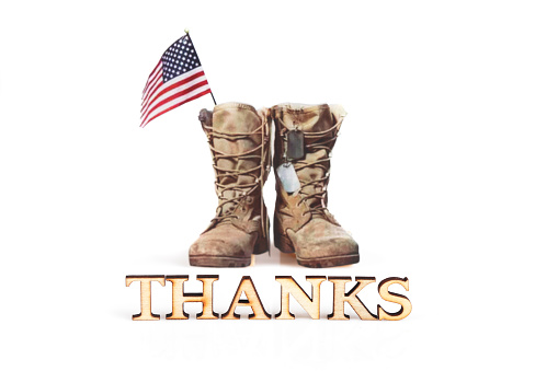Word THANKS and old military combat boots with a small American flag