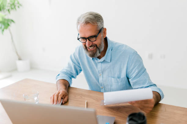 istock Senior businessman using laptop at office 1456582743
