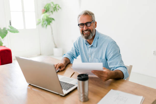 istock Senior businessman using laptop at office 1456582927