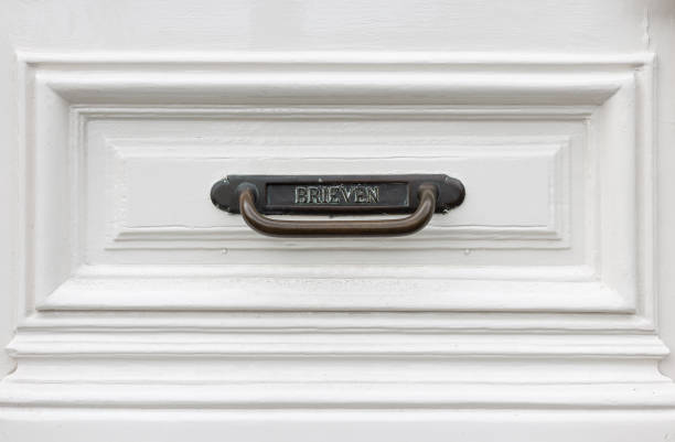 istock Mailbox of the material brass in an old-fashioned white front door. 1456583891