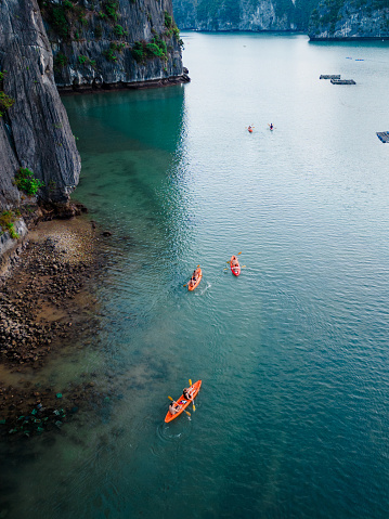 drone view on canoes floating on turquoise water in the halong bay, vietnam