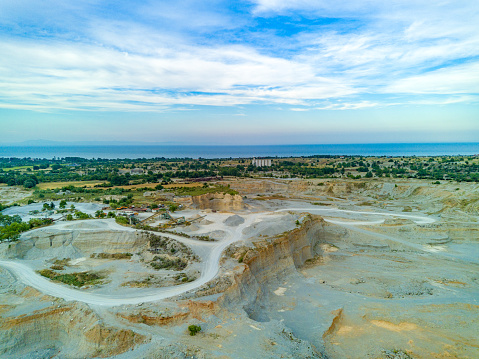 Large wild sand craters in nature of vegetative Montenegro and modern equipment and machines for the extraction of pure white natural sand against the backdrop of the high mountains of Montenegro