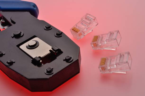 istock A rg45 connector for an internet cable and a twisted pair crimper lie on a multi-colored background. Close-up. 1456585685