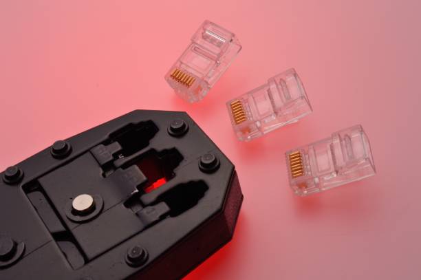 istock A rg45 connector for an internet cable and a twisted pair crimper lie on a multi-colored background. Close-up. 1456585690