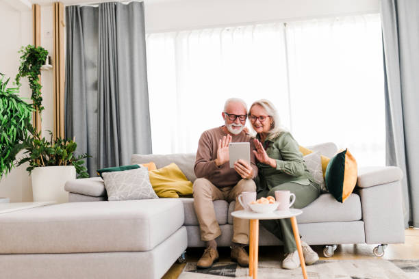 istock Senior retired couple using digital tablet and enjoy talking conversation together on sofa with happiness laugh smile and joyful at home 1456588409