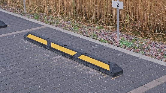 Rubber Curb Bumper Attached to Ground at Outdoor Parking Spot