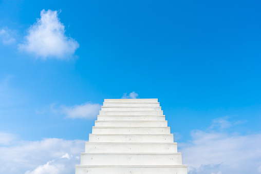 White infinite stair leading up into the blue sky. Concept of motivation, self-development, hope and business opportunity.