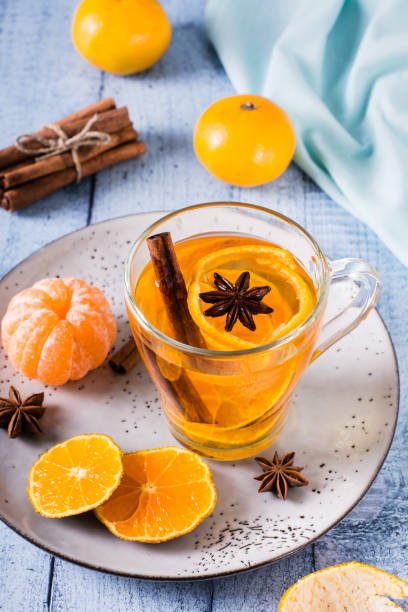 istock Fresh tangerine tea with cinnamon in a cup on the table. Vitamin drink. Vertical view 1456592608