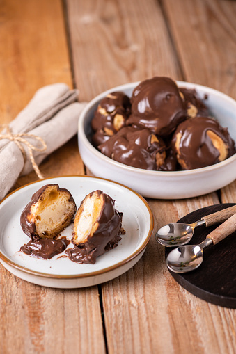 Italian dessert profiteroles with vanilla cream and chocolate cream