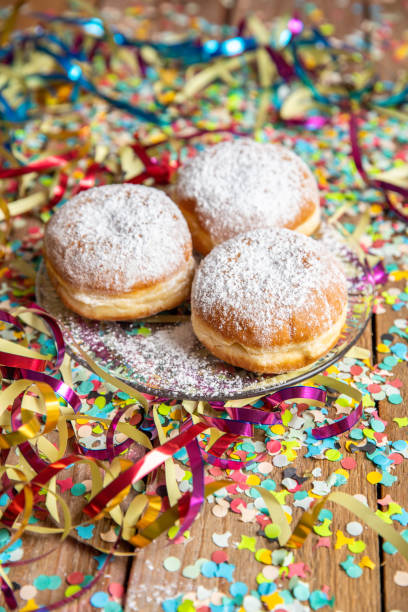 Baked pastry doughnuts Krapfen for carnival Fasching celebration with streamers and confetti stock photo
