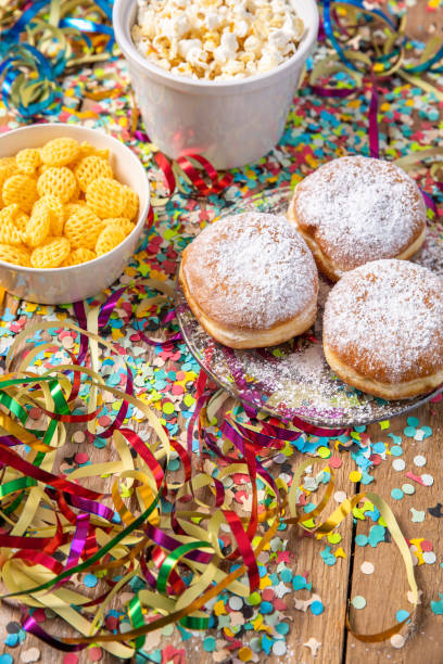istock Baked pastry doughnuts Krapfen for carnival Fasching celebration with party snacks, popcorn streamers and confetti 1456594295