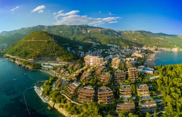 Photo of Panorama of hotel Dukley with chic apartments, gardens and sandy beaches near the Adriatic Sea against the backdrop of the coastal Montenegrin cities