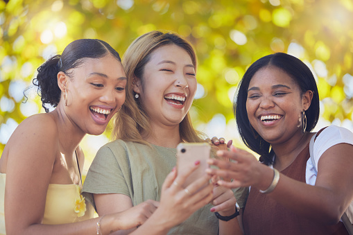 Women, friends and happy phone social media with funny meme, news or online gossip in Los Angeles. Black women, asian and interracial people bond with social network communication for wellness.