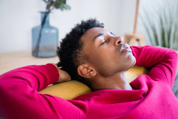 istock Dreamy black man sleeping on sofa at home with closed eyes 1456601002