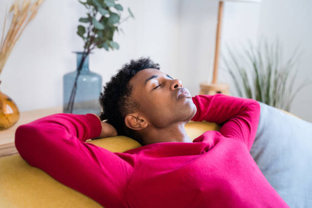 istock Dreamy black man sleeping on sofa at home with closed eyes 1456601047