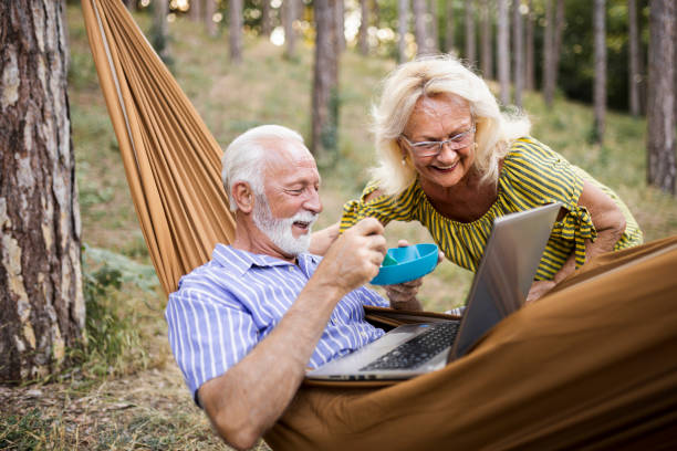 istock Senior couple sharing snack on camping in forest 1456604745