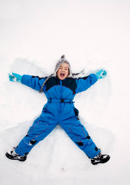 istock Boy having fun lying in the snow 1456605236