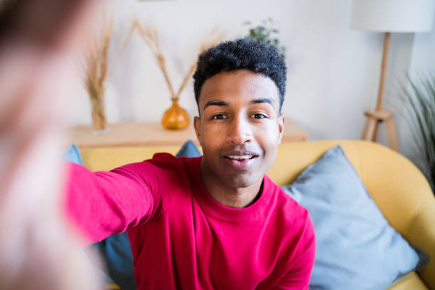 istock Cheerful black man sitting on sofa 1456605316