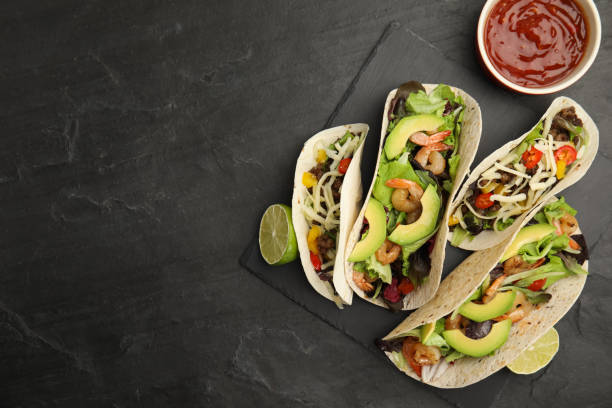 istock Delicious tacos, lime and sauce on black table, flat lay. Space for text 1456606646