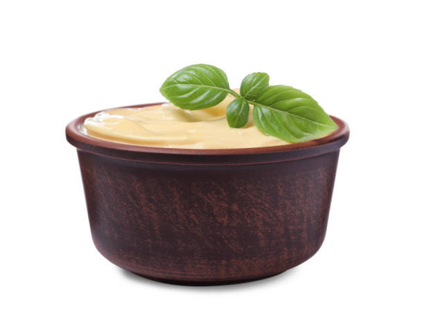 istock Tasty cheese sauce with basil in bowl isolated on white 1456606776