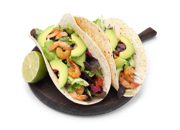 istock Delicious tacos with shrimps, avocado and lime on white background 1456606787