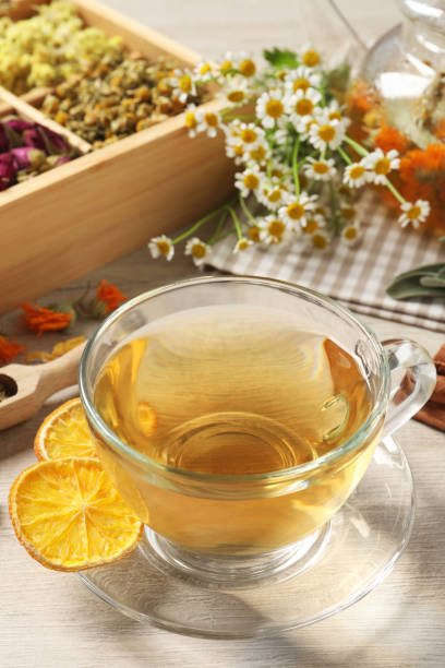 istock Freshly brewed tea and dried herbs on white wooden table 1456606918