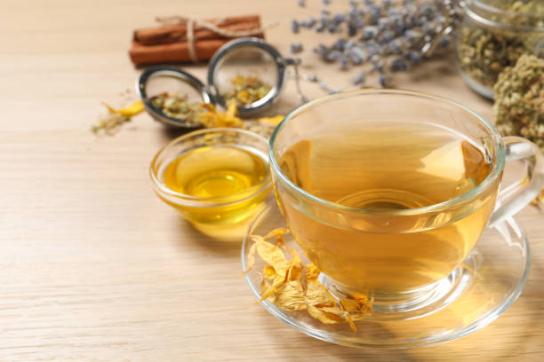 istock Freshly brewed tea and dried herbs on wooden table. Space for text 1456606924