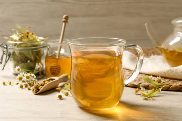 istock Freshly brewed tea and dried herbs on white wooden table 1456607112