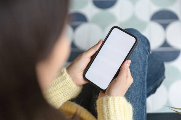 istock Young woman using a smartphone while sitting on the sofa 1456608693