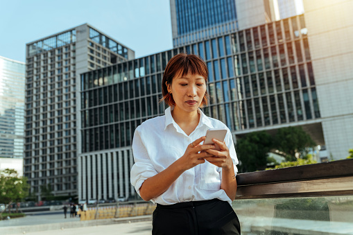 Beautiful Urban Young Woman Looking at Her Mobile Phone