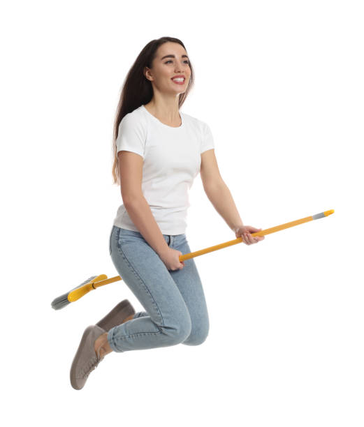 istock Beautiful young woman with broom jumping on white background 1456609794