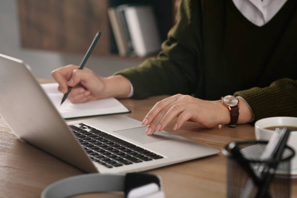 istock Woman with modern laptop learning at table indoors, closeup 1456609855