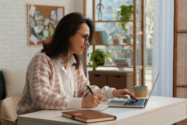 istock Woman with modern laptop learning at home 1456609892