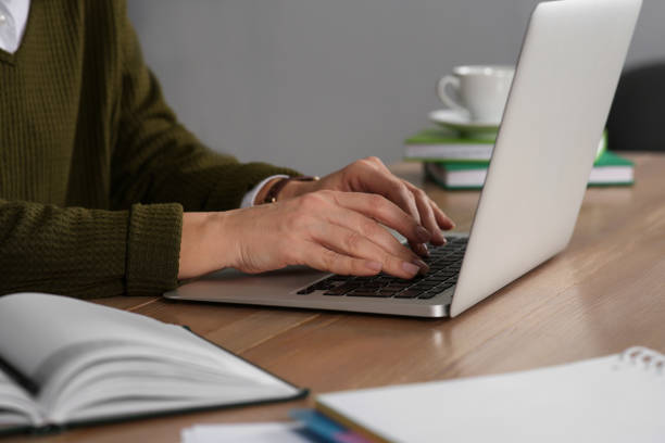 istock Woman with modern laptop learning at table indoors, closeup 1456611474