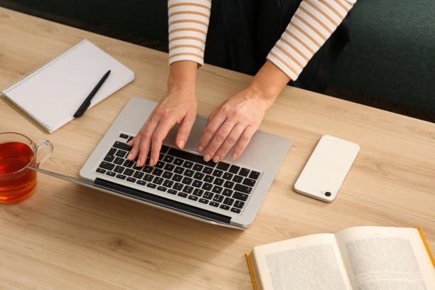 istock Woman with modern laptop learning at table indoors, closeup 1456611675