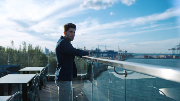 istock Attractive guy looking sea on glass terrace. Successful freelancer enjoy resting 1456614766