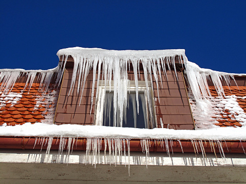 Long icicles hanging from a roof.