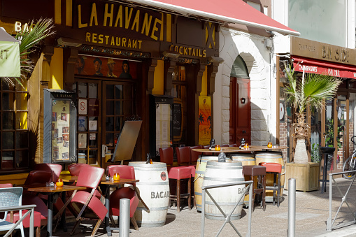 Nice, France - September 18, 2018: The outer part of the restaurant was placed on the pavement. There are tables, chairs and barrels, which serve also as tables.