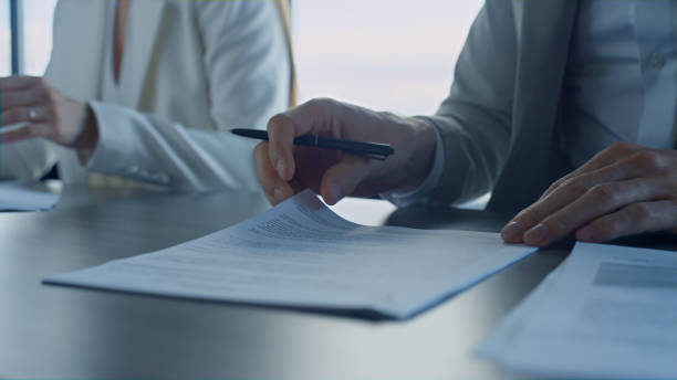 istock Closeup hands checking agreement in office. Business partners reading contract 1456620640