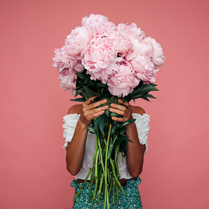 Hermosa mujer emocional sosteniendo ramo de flores photo
