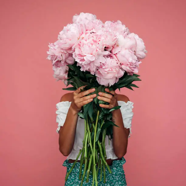 Beautiful emotional woman holding bouquet of flowers