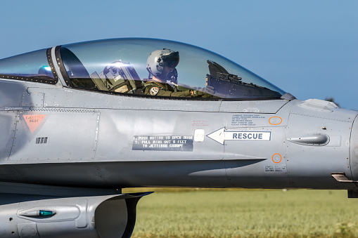 Pilot in the cockpit of a F-16 fighter jet plane taxiing towards the runway at Florennes Airbase. Florennes, Belgium - June 15, 2017